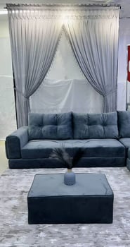Salon d’angle gris en velours avec tapis et rideaux