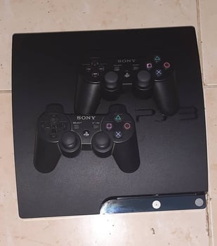 PS3 avec 2 manettes et 13 jeux, en bon état