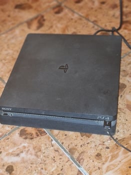 Console PS4 en bon état avec 4 jeux vidéo inclus