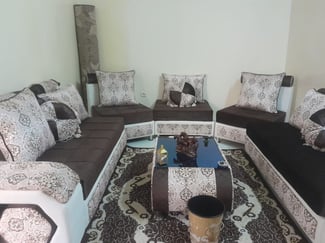 Salon marron beige avec tapis et rideaux peu utilisé