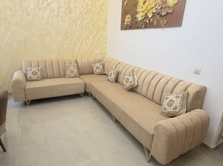 Salon d'angle beige chic et confortable avec coussins décoratifs