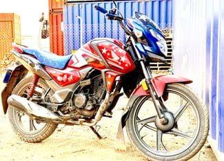 Moto Honda SP125, bien entretenue, rouge et bleu