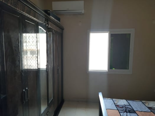 Chambre avec lit, armoire, tables et coiffeuse en bon état