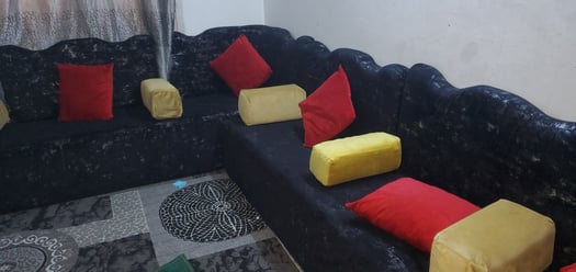 Salon saoudien neuf avec coussins rouges et tapis décoratif