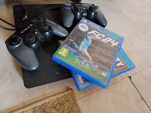 Console PS4 avec 2 manettes et 2 jeux en bon état