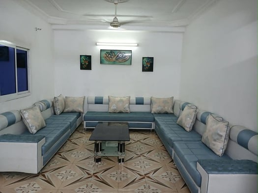 Salon complet en bon état avec table et tableaux